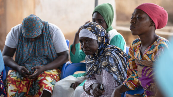 A group of women wearing headscarves take part in a workshop in Ghana.